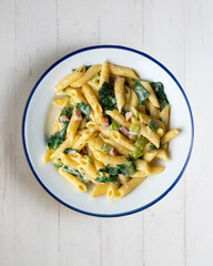 Italian macaroni with chard, ham and cream sauce. Top view table with  decorations.