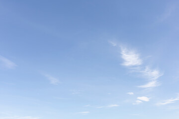 The clear blue sky with white clouds provides a bright and sunny background, enhancing the natural beauty of the landscape on this pleasant summer day