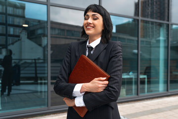 Confident professional woman enjoying a sunny day outside a modern office building in the city