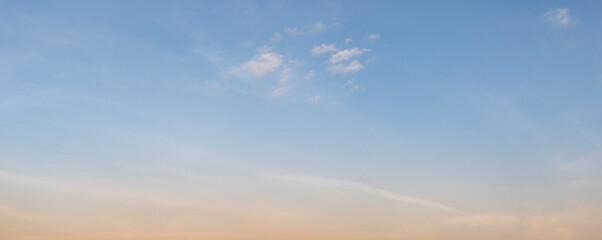 Fototapeta premium The clear gradient sky with white clouds provides a bright and sunny background, enhancing the natural beauty of the landscape on this pleasant summer sunset day