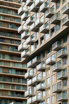 This close-up image of a modern apartment building showcases numerous balconies, highlighting contemporary urban living, architectural design, and residential lifestyle in Rotterdam