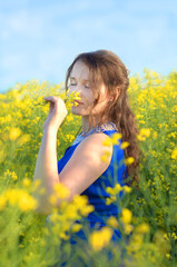 girl in a blue dress in a rapeseed field