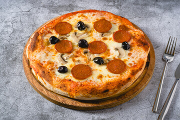 Top view of pepperoni, mushroom and olive neapolitan pizza