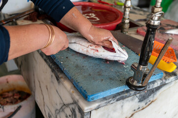 Preparing fresh fish at a market stall in the early morning