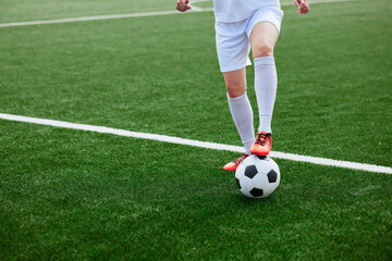 And the soccer player in the uniform and red clothes controlling the soccer ball on the Green Field