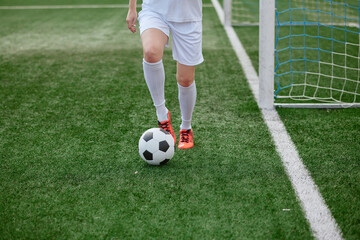 Obraz premium And the soccer player in the uniform and red clothes controlling the soccer ball on the Green Field