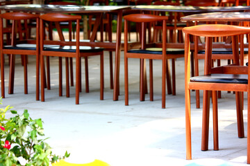 group of wooden vintage chairs on cement loor in restaurant