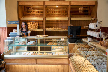 Baker arranging fresh pastries in a cozy bakery during morning hours
