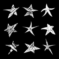 Dancing grunge stars. Set of white grunge stars on a black background. Vector illustration.