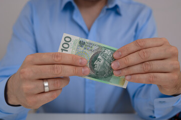 Mężczyzna trzymający w ręku papierowy banknot 