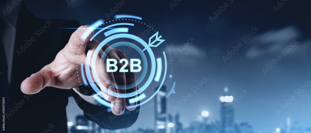 Poster businessman pointing to b2b icon with a digital interface overlay on a blurred cityscape background.