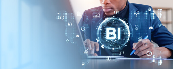 Business professional working on a laptop with holographic icons