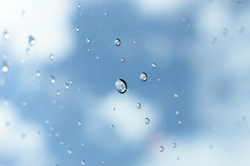 water drop on mirror with blue sky and white cloud background