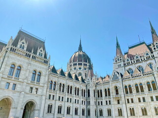 Fototapeta premium The amazing and unique beauty of medieval architecture through the prism of the sun's rays embodied in the buildings of the Hungarian Parliament attracts endless crowds of tourists.