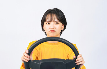 困った顔でハンドルを握って車を運転する女性