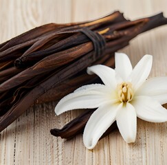 Dried vanilla pods and flower on wooden background