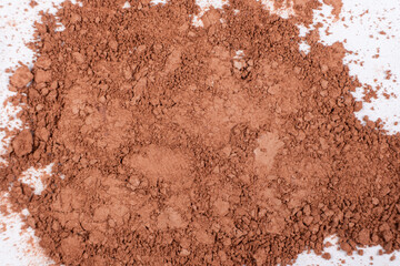 Scattered brown eyeshadow on a white background. Eye shadow texture