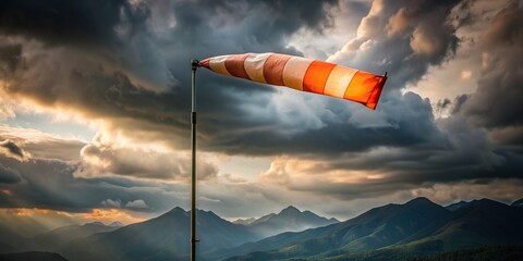 stormy weather, aviation, direction, atmospheric, mountain, motion, navigation, weathered, A torn windsock flutters in the wind against the backdrop of a stormy mountain silhouette