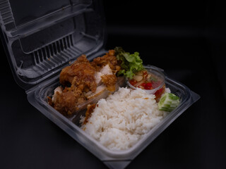 Fried  Pork Rice is put in a clear plastic box.