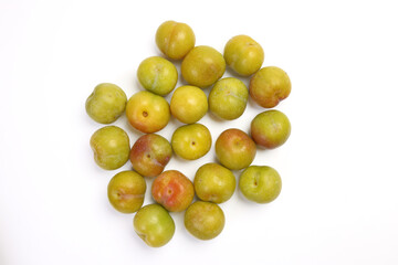 Ripe sweet small mini plum green maroon on white background