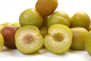 Ripe sweet small mini plum green maroon on white background