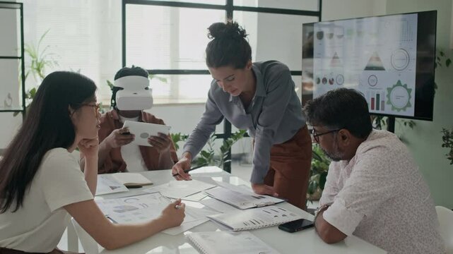 Modern office employees having meeting and testing AR headset