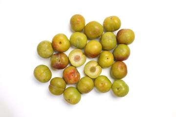 Ripe sweet small mini plum green maroon on white background