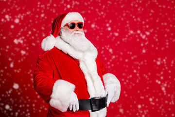 Photo of retired old man grey beard hands belt self-assured prepare save christmas eve spirit protector wear santa costume gloves coat sunglass headwear isolated red color background