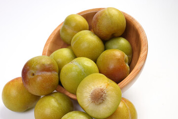 Ripe sweet small mini plum green maroon on white background