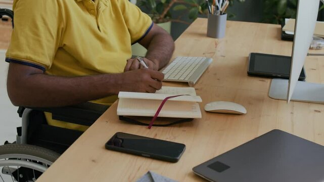 Anonymous freelancer with disability using computer at home office