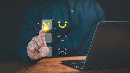 Person select a happy face icon on a feedback scale with neutral and sad face options below. Concept symbolizs customer satisfaction, online reviews, decision-making in user experience evaluation.