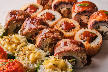 A vibrant sushi platter showcasing a variety of delicious rolls garnished with sauces and fresh ingredients on a stylish table setting
