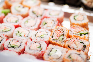 A tray filled with delicious sushi featuring crab and cucumber