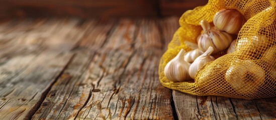 Wooden background sets the stage for a presentation on garlic benefits with a yellow mesh bag in the forefront as a copy space image