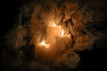 Lit candle flame through heavy smoke fog mist vapour flow twist beautiful mistic