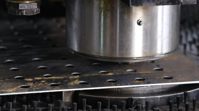 A large industrial punch press forming high precision metal parts. Metal bending machine on a modern industrial factory.