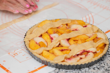 primo piano sulla preparazione di una crostata con fette di albicocche fresche
