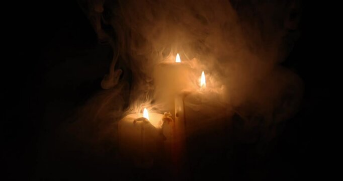 Lit candle flame through heavy smoke fog mist vapour flow twist beautiful mistic