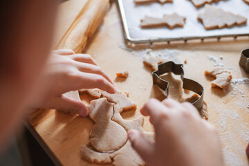 Closeup children's hands make Christmas ginger cookies.