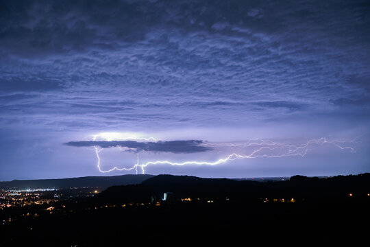 forte temporale con fulmini molto intensi visti da lontano mentre passano sopra il territorio vicino alla citt&agrave; di Gorizia, nell'Italia nord orientale, di notte, in estate