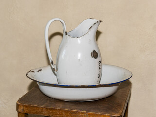 An old white metal jug standing on a table