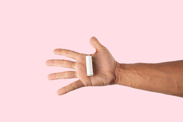 Male hand holding a white battery cell mockup on pink background