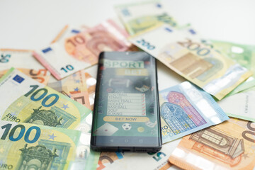 Sports betting website in a mobile phone screen, money