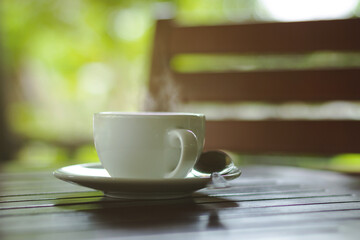 hot coffee on table and green nature background