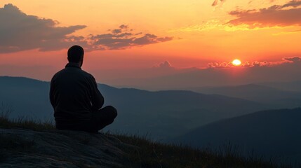 Obraz premium Man Sitting Peacefully on Mountaintop at Dawn