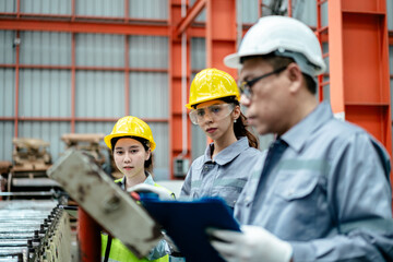 factory workers in uniform together work inspecting operation manufacturing Metal Roofing Sheet Machine in the factory metal sheet, Metalwork roof manufacturing and quality control process.