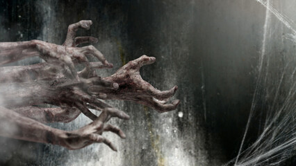 Group of zombie hands with bloody wound shown in a dark room with a cobweb spider web in the...