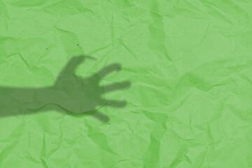 Shade of werewolf hands with fur and black claws on a green background. The hand is reaching out,...