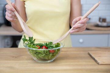 Woman preparing a salad in the kitchens. Home cooking. Concept of Healthy Eating, Diets and Nutrition. Selective focus, Close Up