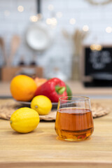 Glass of juice or other beverage on the kitchen table with various vegetables and fruits on the background. Concept of Healthy Eating, Diets and Nutrition. Selective focus, Close Up
